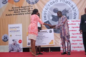 Mrs Iyabo Akai (L) presenting the award to the 1st prize winner Fine Arts, Mfon Okon Essien