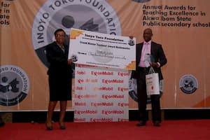Mrs Rita Umoren of ExxonMobil (sponsors of the Grand Mentor Awards) presenting the award to the Grand Mentor Award winner Mathematics, Mr Nsikak Iyire