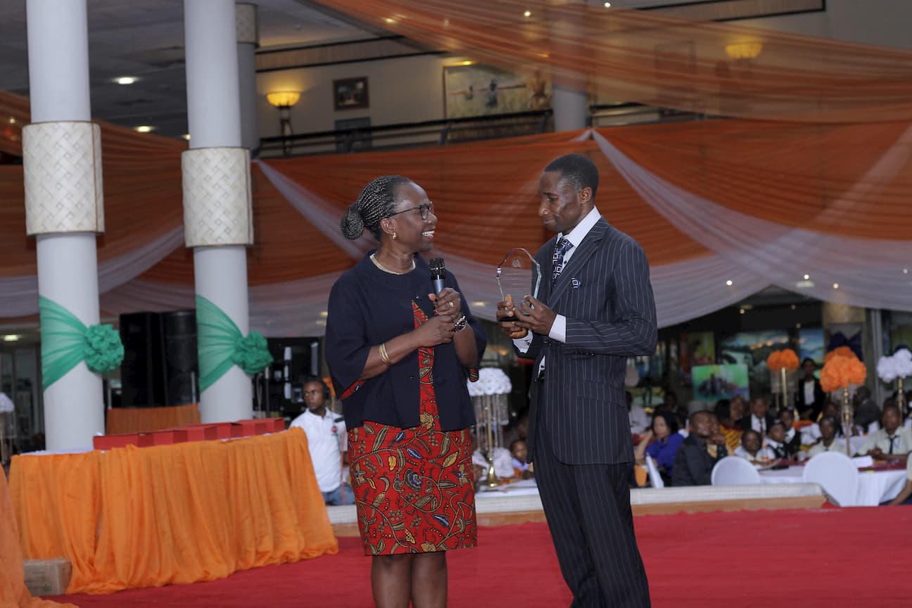 DR MYMA BELO OSAGIE PRESENTING AN AWARD TO THE 2ND PLACE WINNER ECONOMICS ANIEKAN OKONAH UDOH