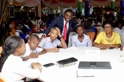 Emmanuel Tishion representing the Mentor Mr. Idorenyin Enang with the students of his adopted school