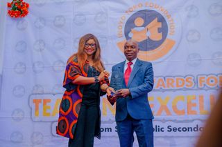 Mrs. Emelda Abba; Representative of Anchor Insurance Company Ltd Presenting Award to Kubiat Bassey Umo, 1st Prize Winner Economics