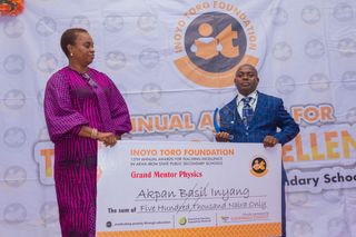 Mrs. Nkoyo Etuk of Savannah Energy Presenting Grand Mentor's Award and Cheque to Winner, Physics, Basil Inyang