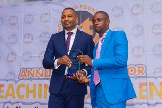 Okwudili Onyia of Savannah Engergy Ltd, Rep. Mr. Aniekan Ukpanah - Award Sponsor, Presenting Award to Second Prize Winner, Utibe Raphael Udo